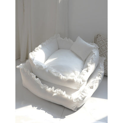 White pet bed with ruffled edges on a light surface