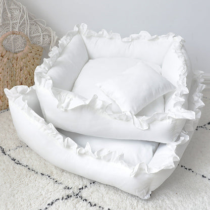 White ruffled pillowcases on a marble surface with a textured rug and decorative item in the background.