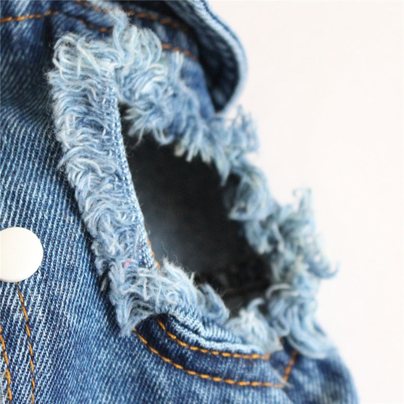 Close-up of a denim jacket with frayed edges on a white background
