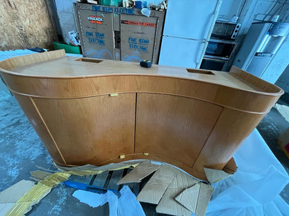 Wooden furniture piece on a floor with tools and boxes in the background