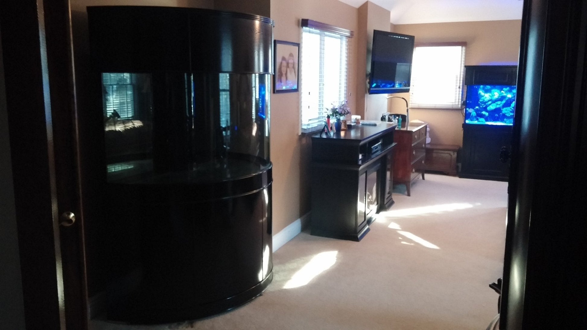 Living room with a large black entertainment center and multiple TVs.