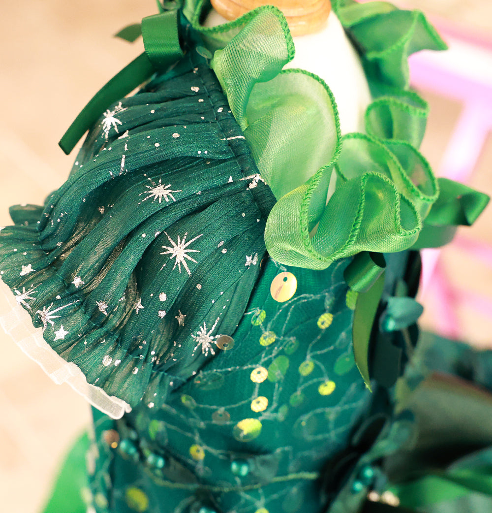 Green decorative item with ribbons and star patterns on a neutral background