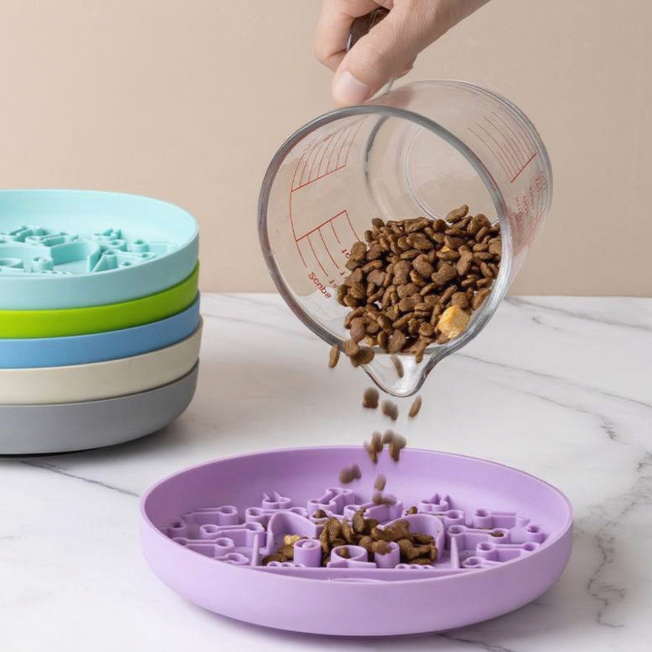 Purple pet bowl with a maze design being filled with dog food using a measuring cup.