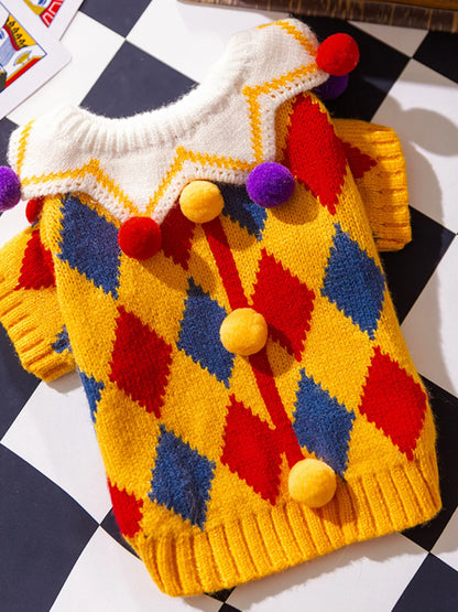 Colorful knitted sweater with diamond pattern and pom-poms on a checkered background