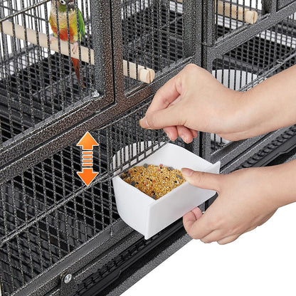 Person feeding a bird in a cage with a white dish containing bird food.