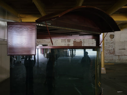 Wooden boat inside a warehouse with brick wall and concrete floor