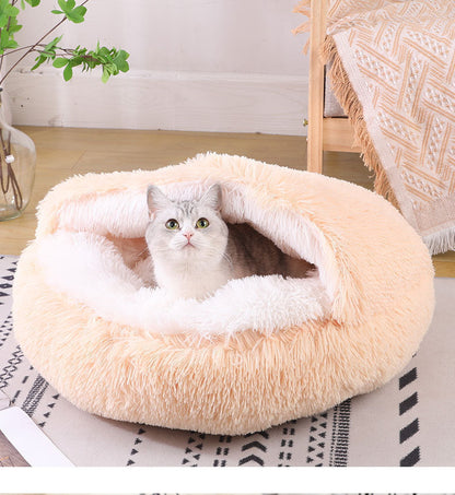 Cat lying inside a plush beige pet bed on a patterned rug.
