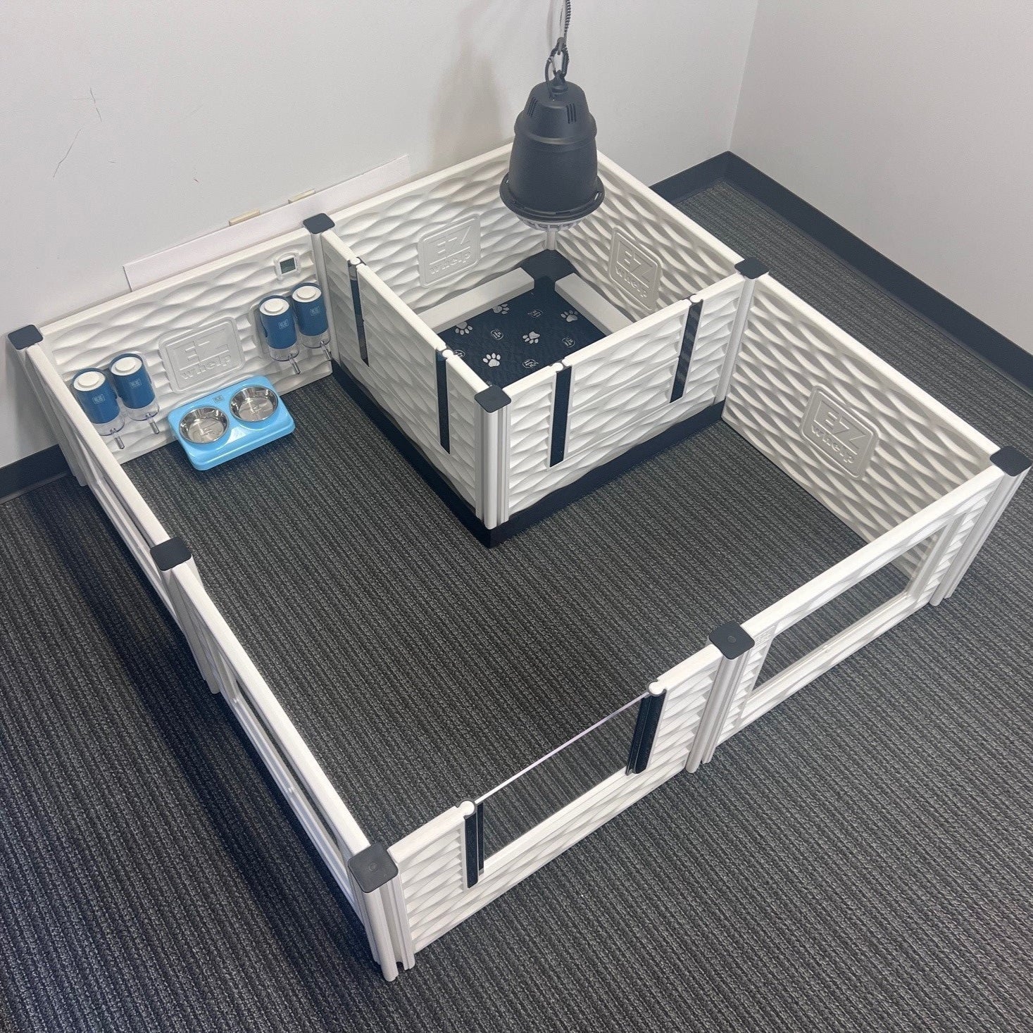 Pet playpen with various accessories on a carpeted floor.