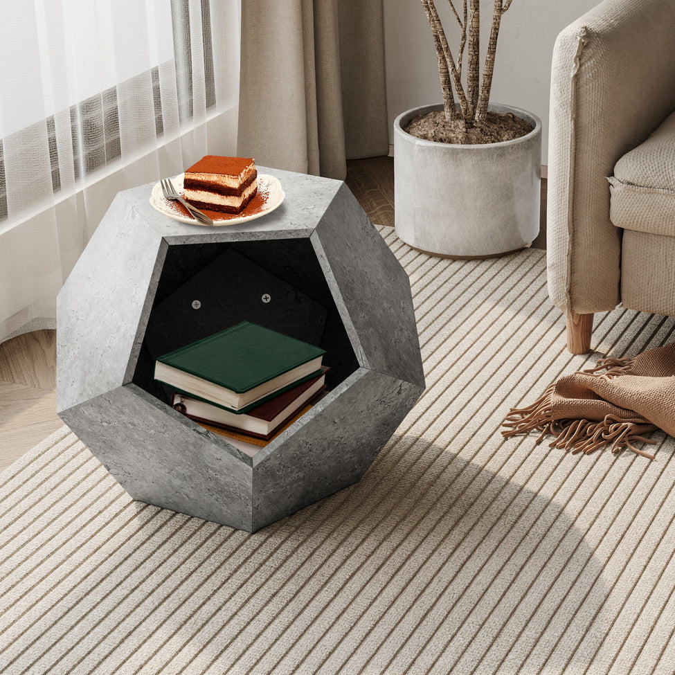 Hexagonal concrete side table with books and a plate of food in a living room setting.