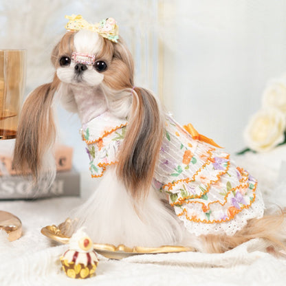 Dog in a decorative outfit with a bow, sitting on a white surface.