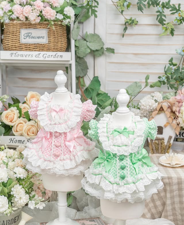 Two decorative urns, one pink and one green, surrounded by flowers and garden-themed decor.