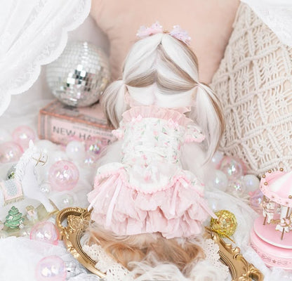 Person with a doll wearing a pink dress surrounded by decorative items