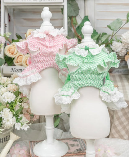 Two mannequin heads wearing pink and green crochet hats with ruffles on a decorative background.