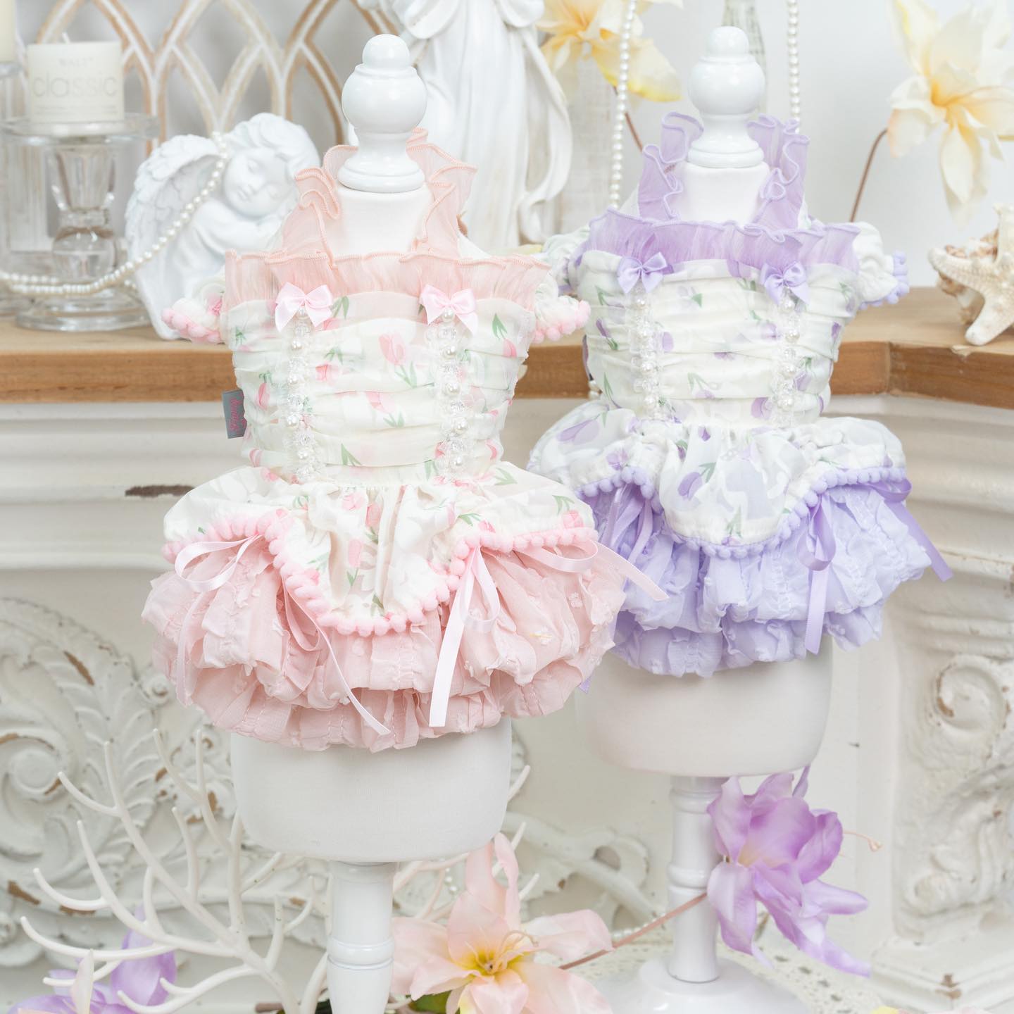 Pastel-colored ruffled petticoats on mannequins with a decorative background.