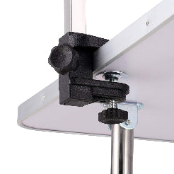 Close-up of a clamp holding a white board on a white background
