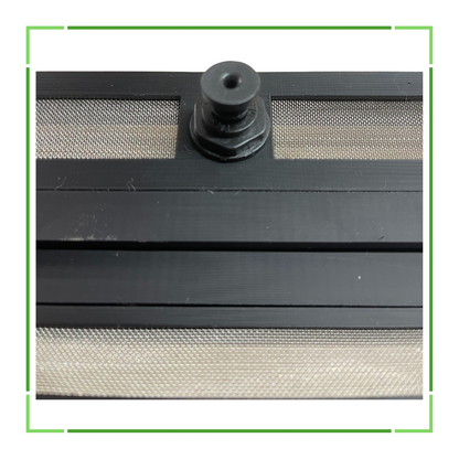 Close-up of a black screen door with a mesh pattern and a central pivot point.