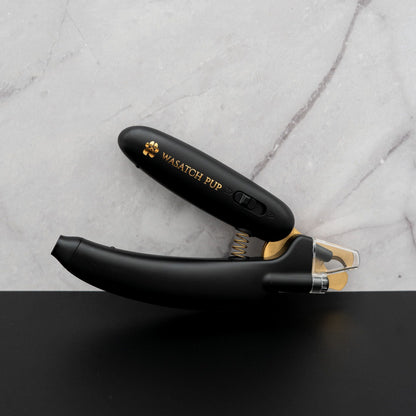 Black pet nail trimmer with 'Wasatch Pup' branding on a gray marble background