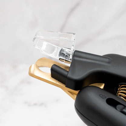 Close-up of a black and gold tool on a light gray background