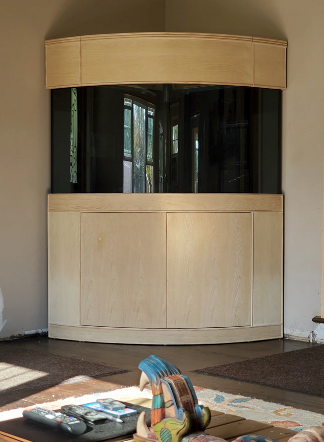 Large fish tank with wooden cabinet in a room setting