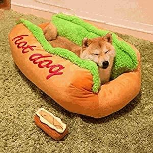 Dog lying in a hot dog-shaped pet bed on a carpeted floor.