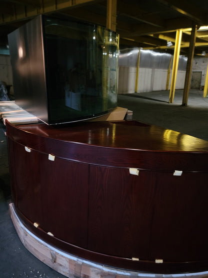 Wooden reception desk with curved front in a warehouse setting