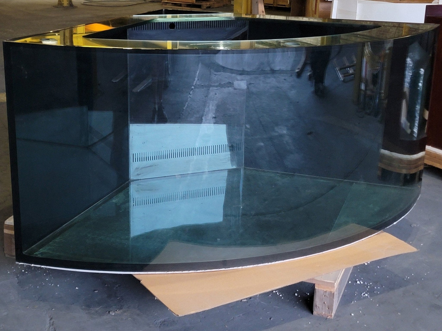 Large black curved glass panel on a stand in an indoor setting