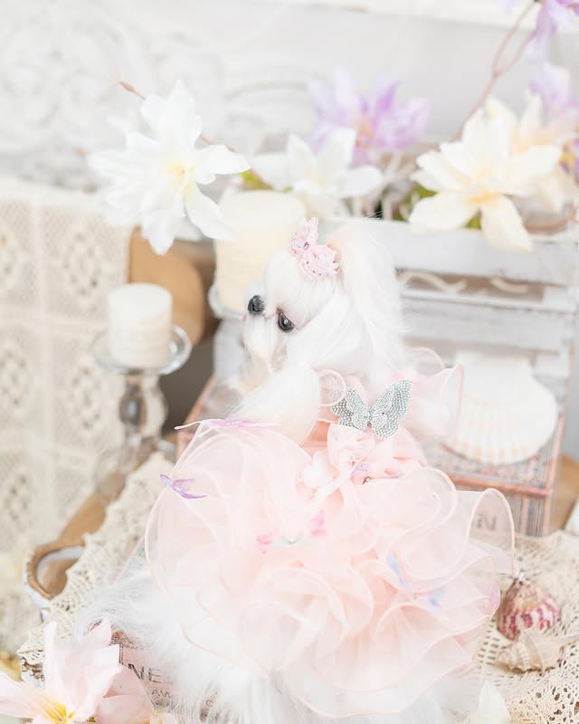 Delicate white teddy bear with a pink bow in a soft, blurred background