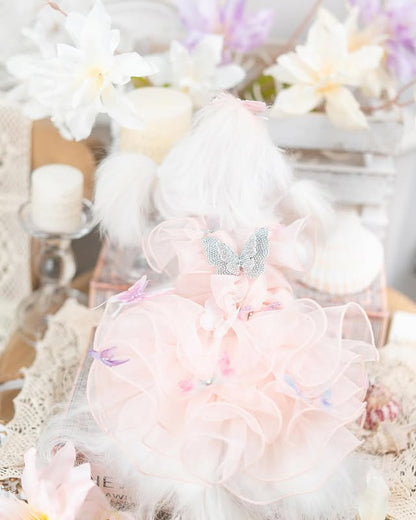 Pastel-colored plush toy with decorative elements on a soft, textured background