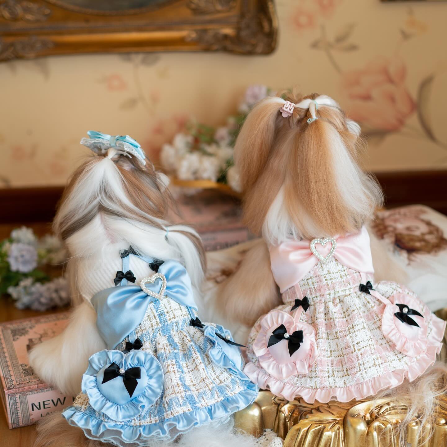 Two dolls with styled hair and dresses in a decorative setting