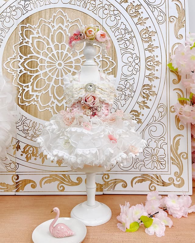 Decorative cake stand with floral decorations against an ornate gold and white background