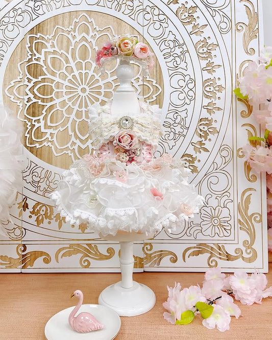 Decorative cake stand with floral decorations against an ornate gold and white background