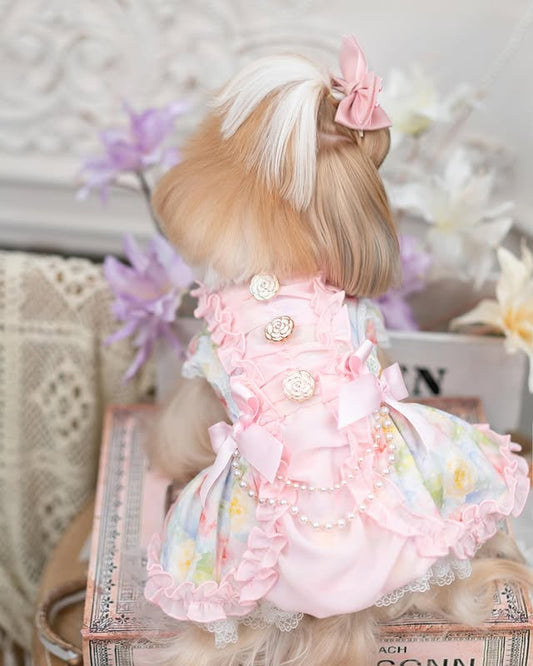 Doll with blonde hair and a pink dress sitting on a surface with a decorative background.