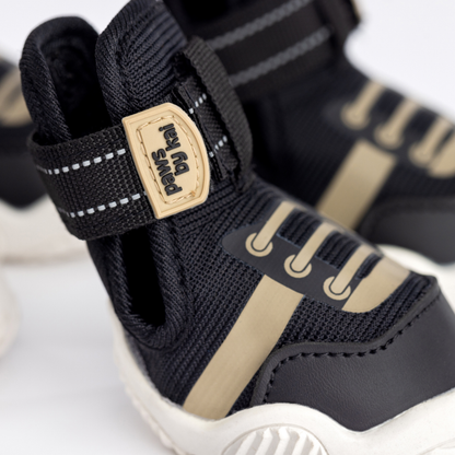 Black and beige dog boots with brand label on a white background