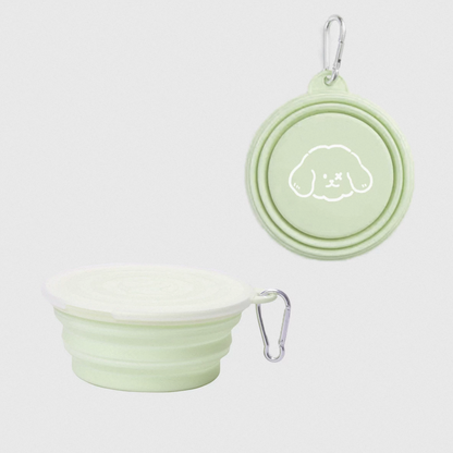 Light green silicone travel bowl and lid with a cute dog design on a white background