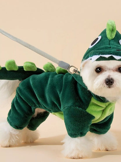 Dog wearing a green dinosaur costume on a beige background