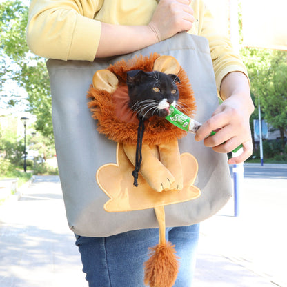 Person holding a tote bag with a lion plush toy attached, outdoors.