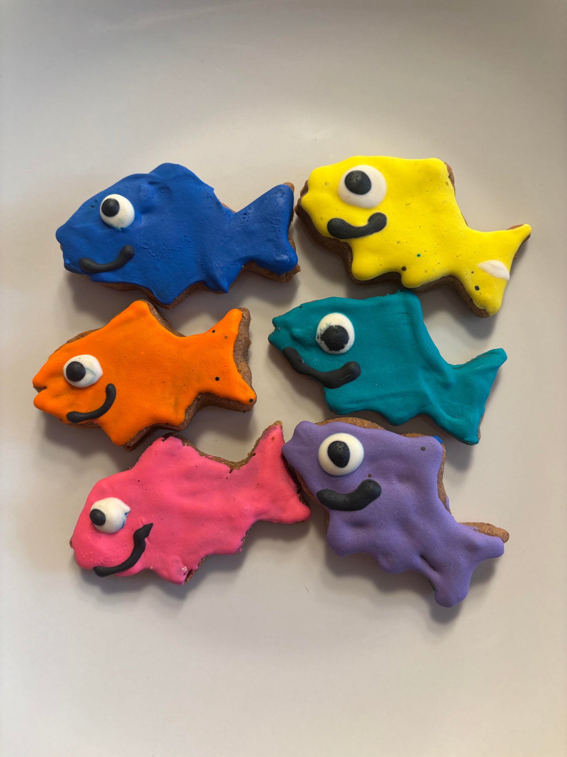 Colorful fish-shaped cookies on a plain background