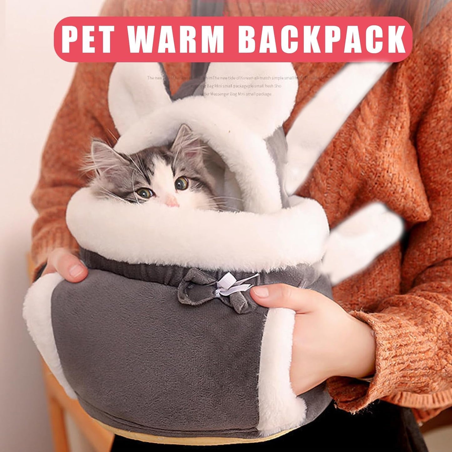 Pet warm backpack with a small cat inside, held by a person wearing an orange sweater.