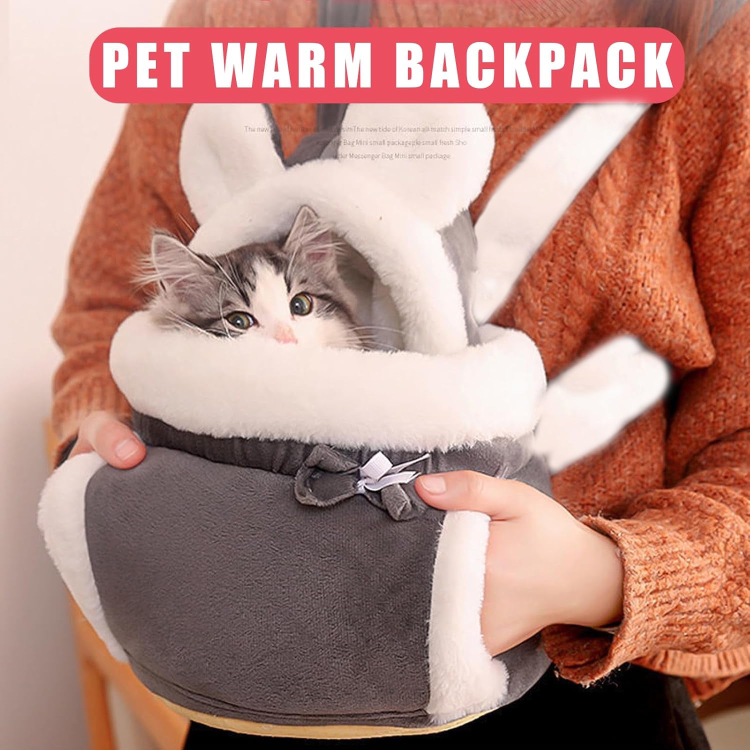 Pet warm backpack with a small cat inside, held by a person wearing an orange sweater.