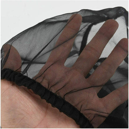 Brown lace wig cap with mesh back held by a hand against a light gray background