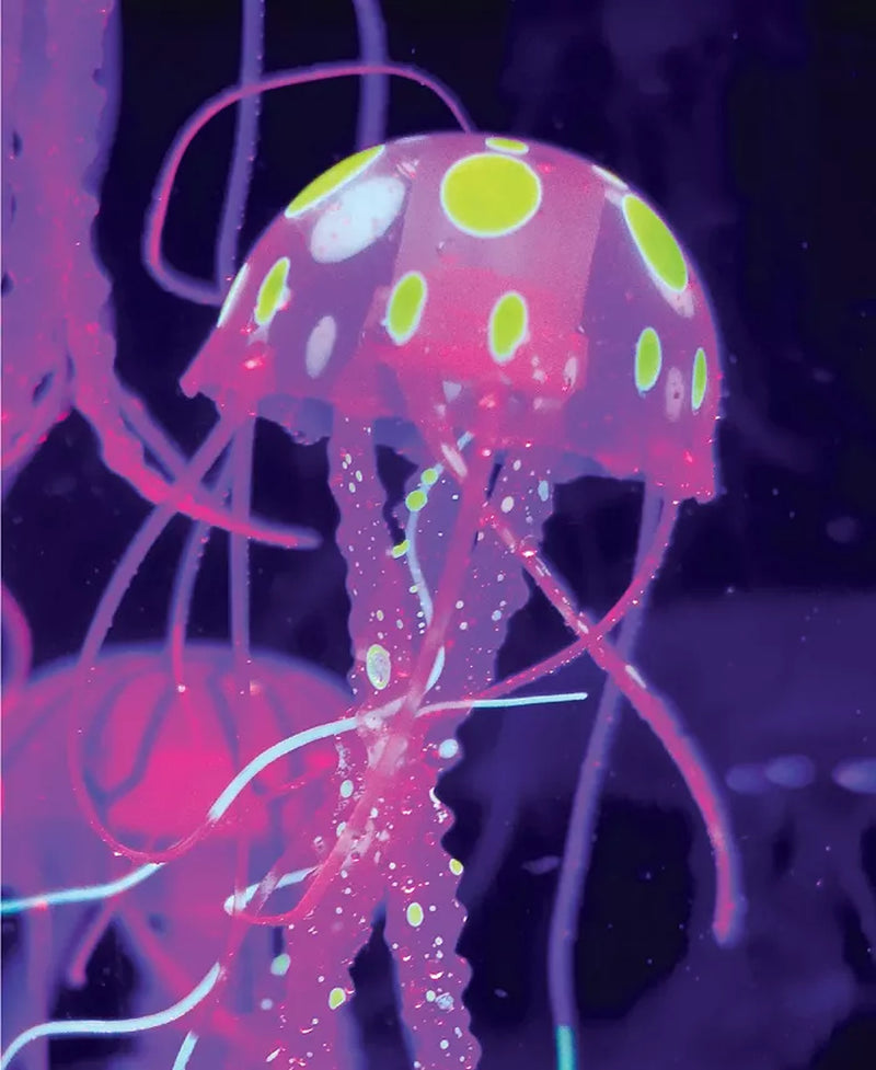 Glowing jellyfish with pink and green polka dot pattern on a dark background