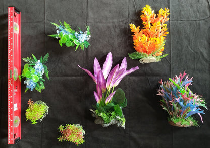 Assorted artificial aquarium plants on a black background with a ruler for scale.