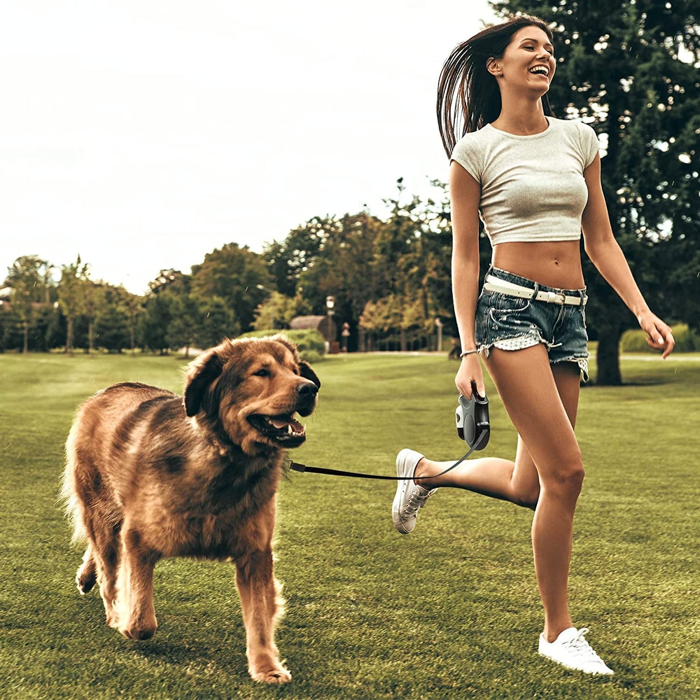 Woman running with a dog on a leash in a park