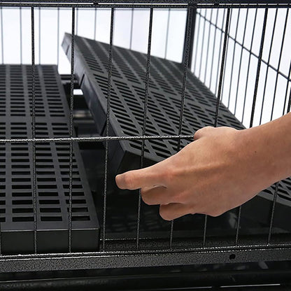 Person adjusting a black metal grid inside a larger metal cage.