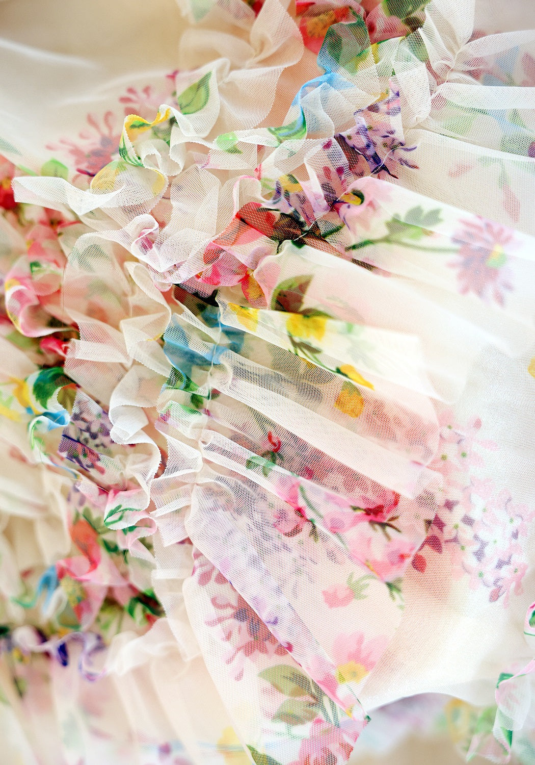 Floral dress with ruffled details in pastel colors on a white background