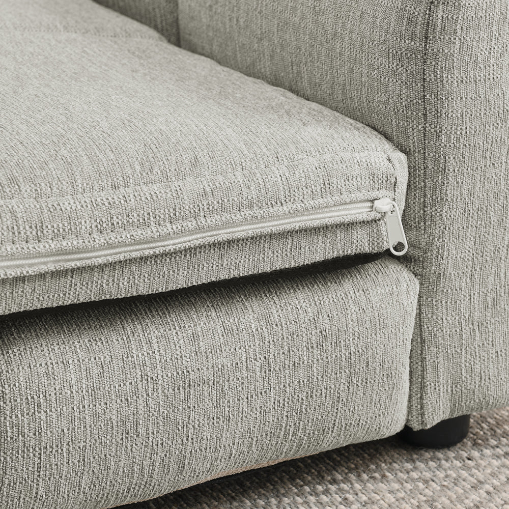 Gray fabric sofa with zipper detail on a textured surface