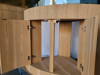 Wooden cabinet with open doors on a reflective surface