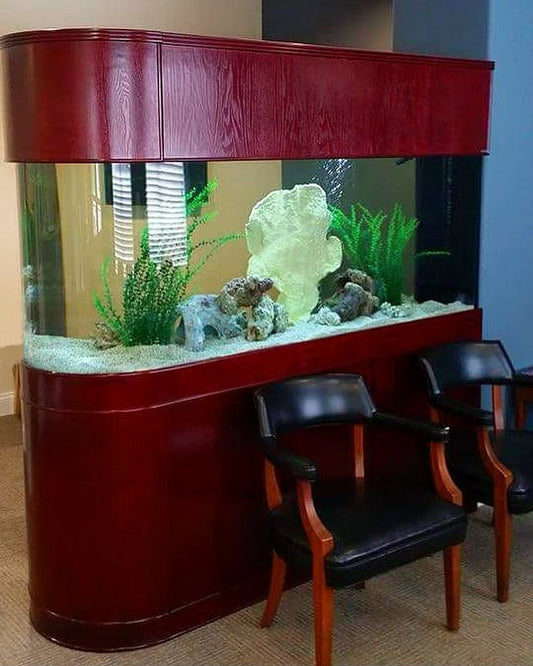 Large fish tank with decorative elements in a room with chairs.