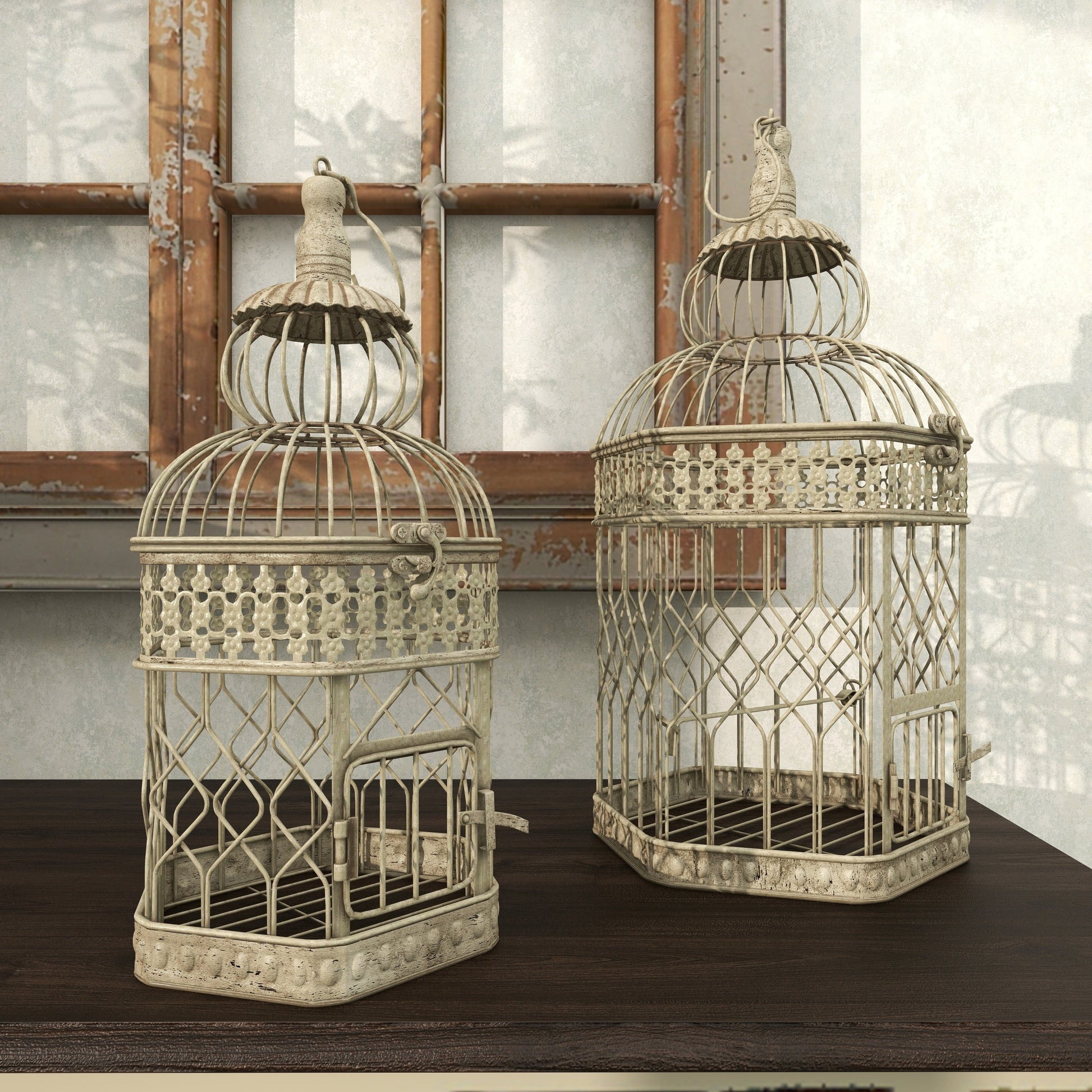 Two decorative birdcages on a wooden surface with a neutral background