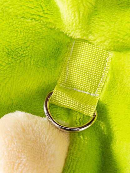 Close-up of a green plush toy with a white paw and metal ring attachment.